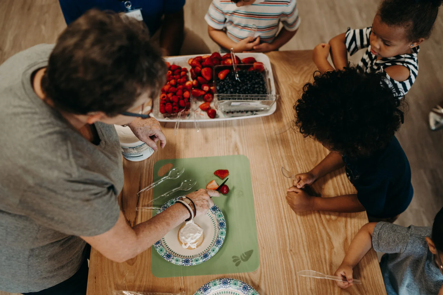 Children happily enjoying a healthy snack together at a welcoming preschool in Alpharetta, Georgia, fostering community, self-help skills, and a love for nutritious eating.